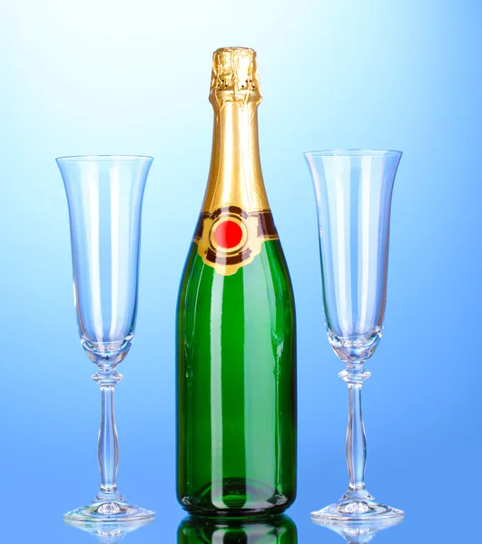 Bottle of champagne and goblets on blue background — Stock Photo, Image