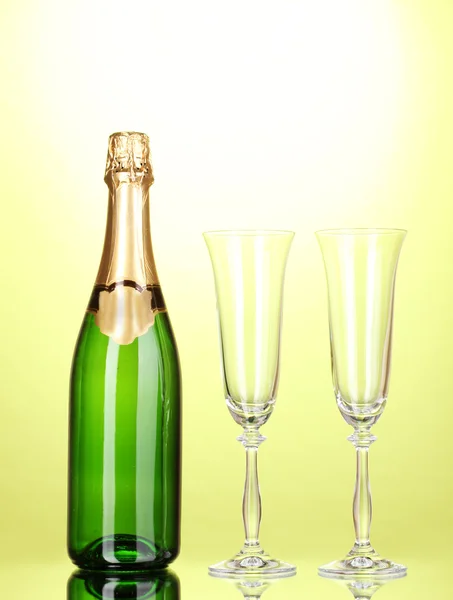 Bottle of champagne and goblets on green background — Stock Photo, Image