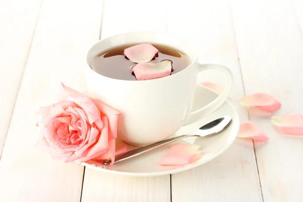 Cup of tea with rose on white wooden table — Stock Photo, Image