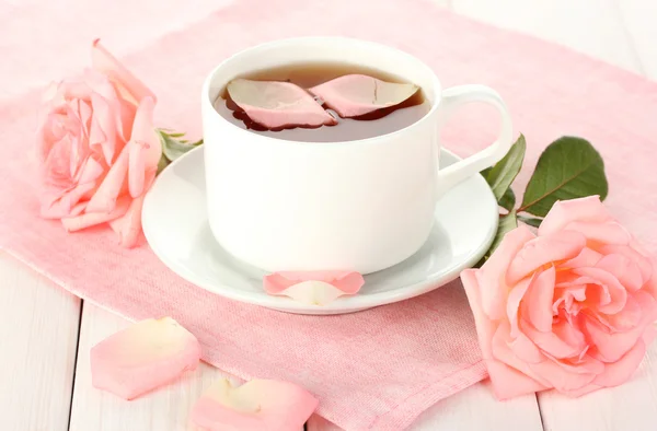 Kopje thee met rozen op witte houten tafel — Stockfoto