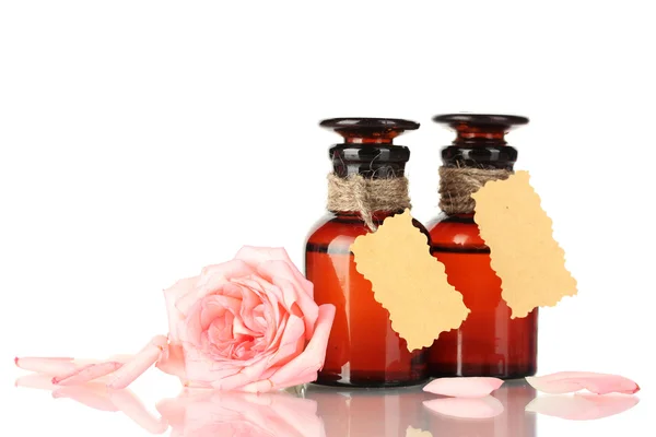 Бутылки масла и розы изолированы на белом — стоковое фото