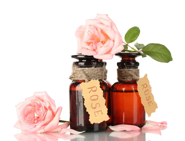 Bottles of oil and roses isolated on white — Stock Photo, Image