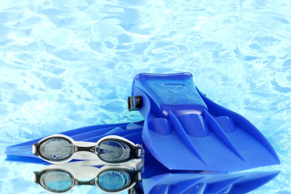 Aletas y gafas azules sobre fondo marino azul — Foto de Stock