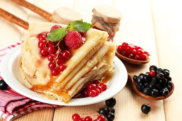 Delicious pancakes with berries, jam and honey on wooden table — Stock Photo, Image