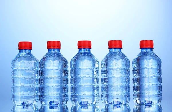 Botellas de plástico de agua sobre fondo azul —  Fotos de Stock