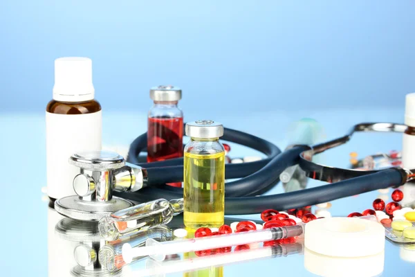 Medicines and a stethoscope on a blue background close-up — Stock Photo, Image