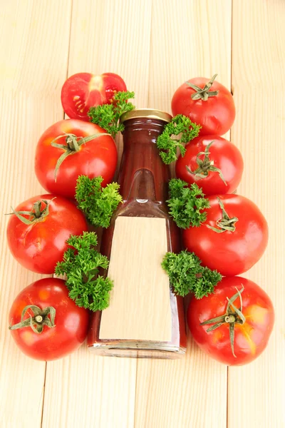 Ketchup in bottle and tomatoes on wooden table — Stock Photo, Image