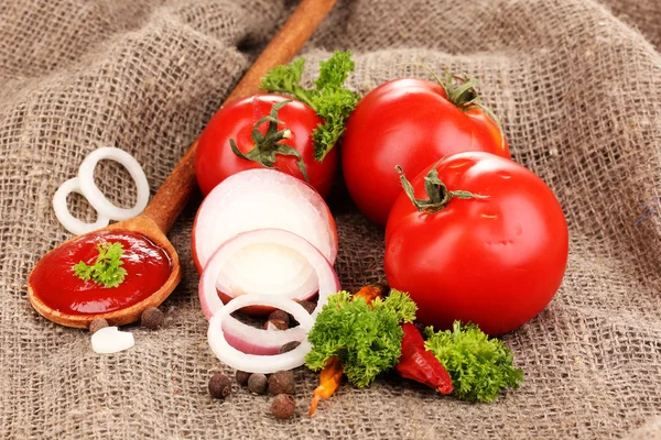 Ketchup and ripe tomatoes on sacking close-up — Stock Photo, Image