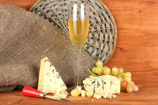 Composition of blue cheese and a glass of wine with grapes on wooden background — Stock Photo, Image