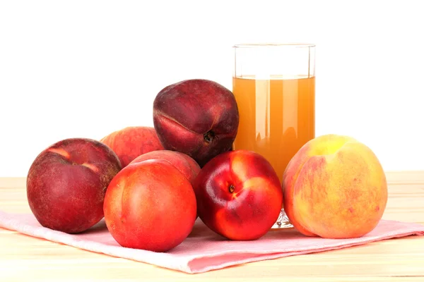 Reife Pfirsiche und Saft auf Holztisch auf weißem Hintergrund — Stockfoto