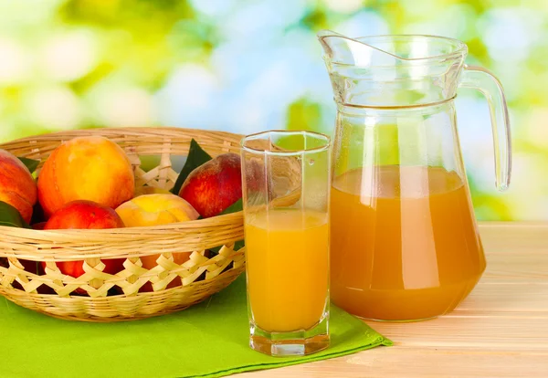 Mogna persikor och juice på träbord på naturliga bakgrund — Stockfoto