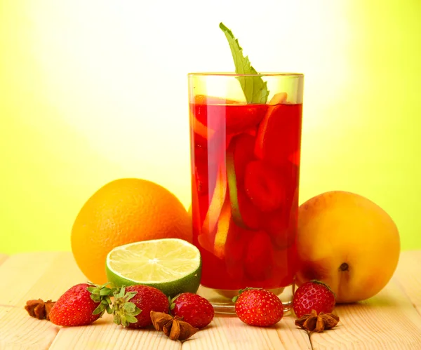 Osvěžující sangria sklenice s ovocem, na dřevěný stůl, na zelené poz — Stock fotografie