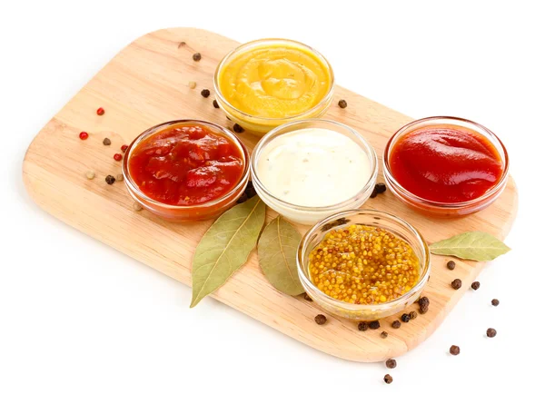 Various sauces on chopping board isolated on white — Stock Photo, Image