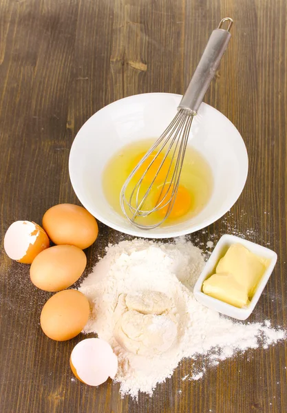 Eggs, flour and butter close-up on wooden table — Stock Photo, Image