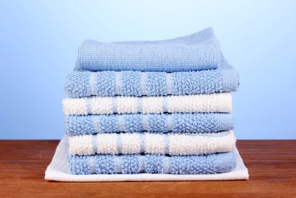 Kitchen towels on wooden table on blue background close-up — Stock Photo, Image