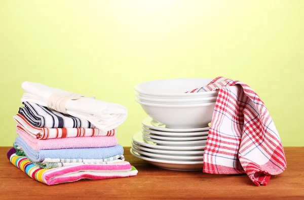 Küchentücher mit Geschirr auf grünem Hintergrund Nahaufnahme — Stockfoto