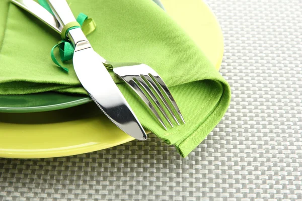 Platos verdes vacíos con tenedor y cuchillo sobre un mantel gris — Foto de Stock