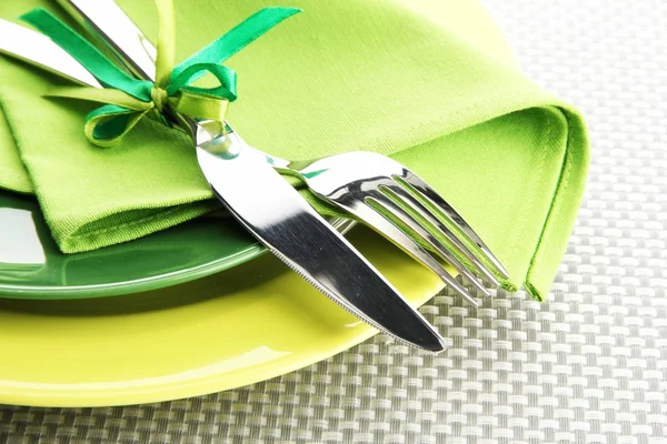 Green empty plates with fork and knife on a grey tablecloth — Stock Photo, Image