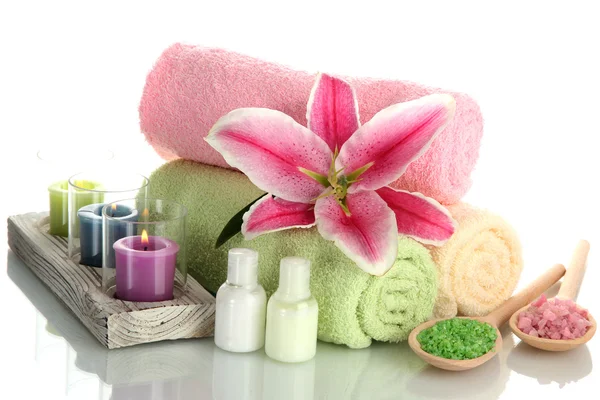 Towels with lily, aroma oil, candles and sea salt isolated on white — Stock Photo, Image