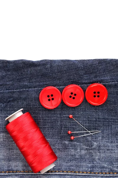 Boutons à coudre colorés avec fil sur jeans isolés sur blanc — Photo