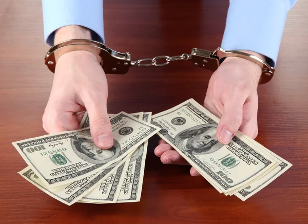 Businessman in handcuffs counts the money for bribes — Stock Photo, Image
