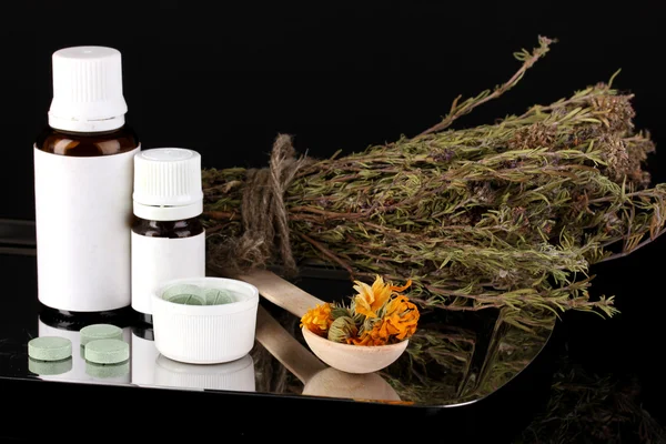 Bottles of medicines and herbs on black background. concept of homeopathy — Stock Photo, Image