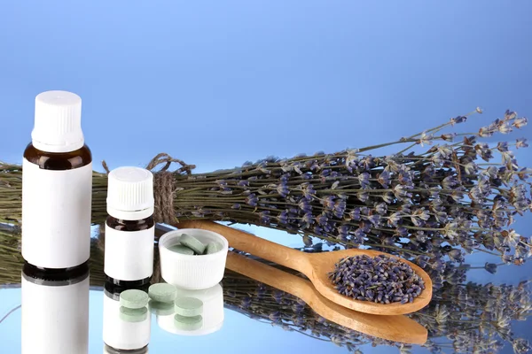 Frascos de medicamentos y hierbas sobre fondo azul. concepto de homeopatía — Foto de Stock