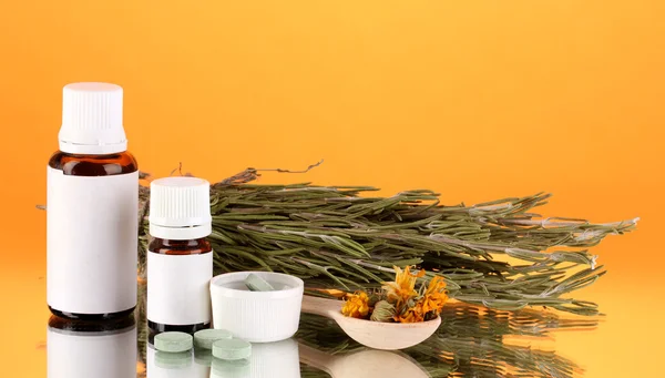 Frascos de medicamentos y hierbas sobre fondo naranja. concepto de homeopatía — Foto de Stock