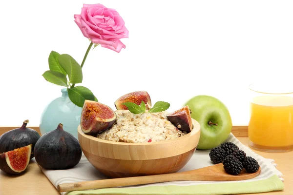 Tasty oatmeal with fruits glass of juice, on wooden table — Stock Photo, Image