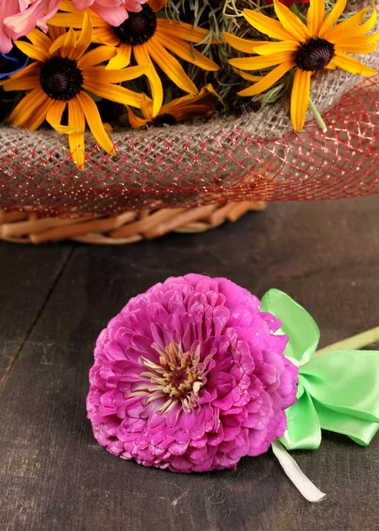 Belo buquê de flores brilhantes em saquear no fundo de madeira — Fotografia de Stock