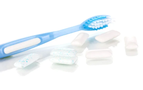 Goma de mascar y cepillo de dientes de cerca aislados en blanco —  Fotos de Stock