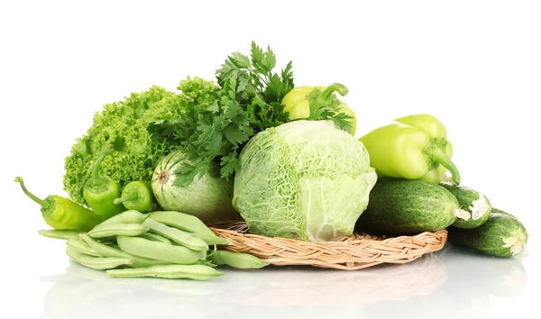 Verduras verdes frescas en estera de mimbre aislada en blanco — Foto de Stock