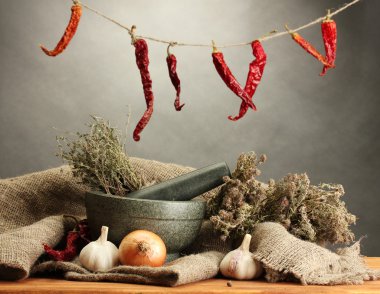 harç ve sebzeler, gri arka plan üzerinde ahşap masa üzerinde kurumuş otlar