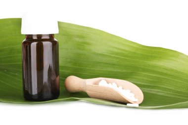 yeşil yaprak üzerinde beyaz izole tablet ile ilaç şişesi