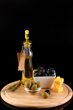 Biberiye, zeytinyağı ve gemiye peynir bir kase içinde siyah ve yeşil zeytin