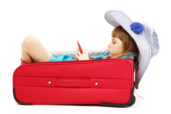 Portrait of little girl in travel case with hat isolated on white — Stock Photo, Image