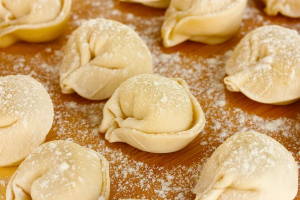 Dumplings brutos na placa de corte close-up — Fotografia de Stock