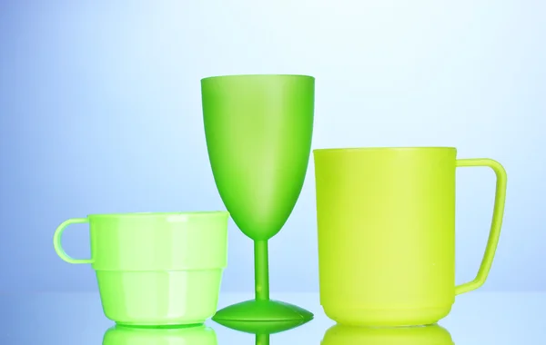 Bright plastic tableware on blue background — Stock Photo, Image