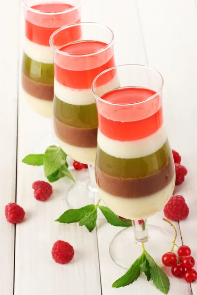 Fruit gelei in glazen, bessen en mint op houten tafel — Stockfoto