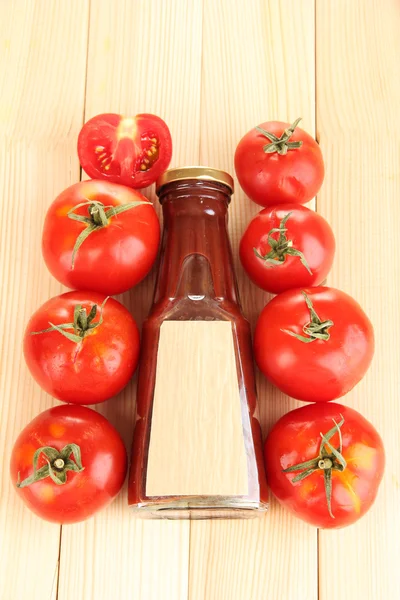 Ketchup in fles en tomaten op houten tafel — Stockfoto