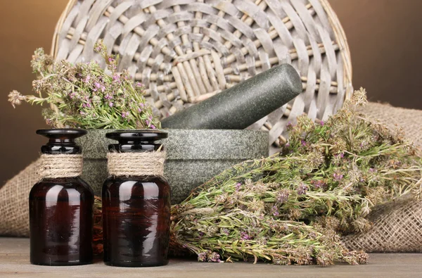 Thyme herb and mortar on wooden table on brown background — Stock Photo, Image