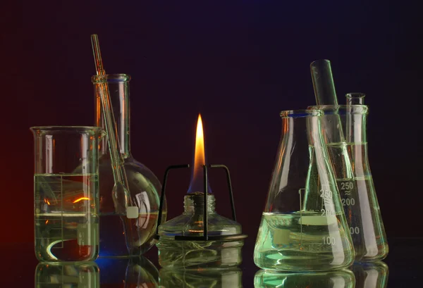 Spiritlamp and test-tubes on blue-red background — Stock Photo, Image