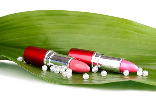 Lipsticks on green leaf isolated on white — Stock Photo, Image