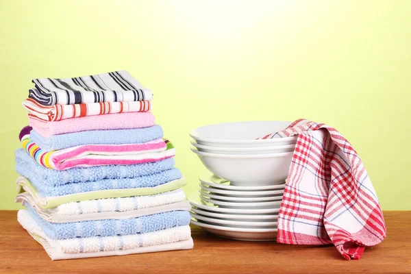 Кухонные полотенца с посудой на зеленом фоне крупным планом — стоковое фото