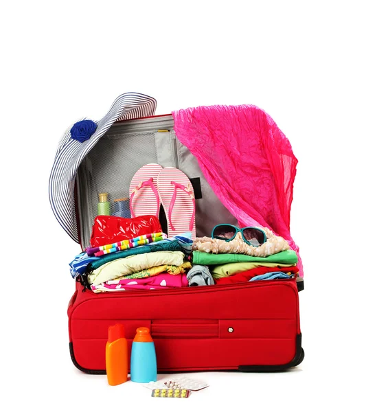 Red travel suitcase with personal belongings isolated on white