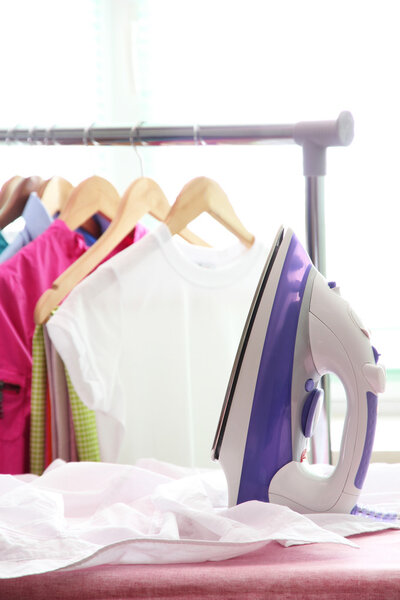 Electric iron and shirt, on cloth background