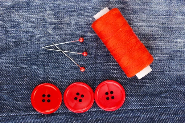 Colorful sewing buttons with thread on jeans closeup — Stock Photo, Image