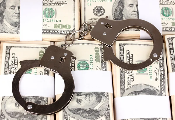 Handcuffs on the packs of dollars close-up — Stock Photo, Image