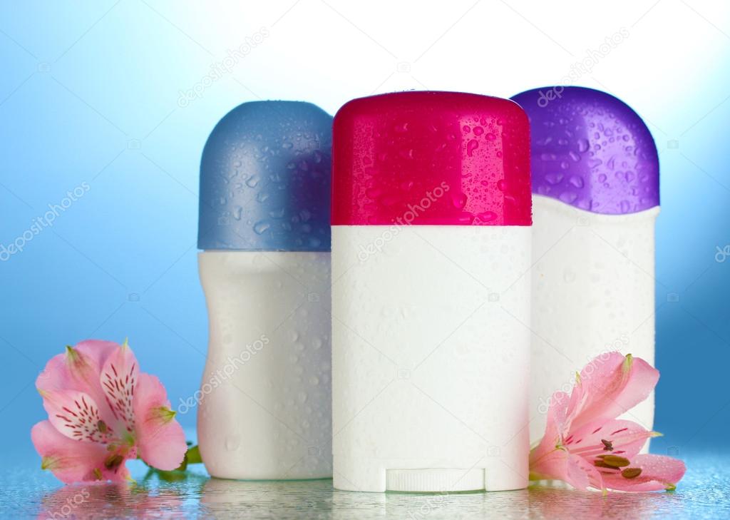 Deodorants with flowers on blue background