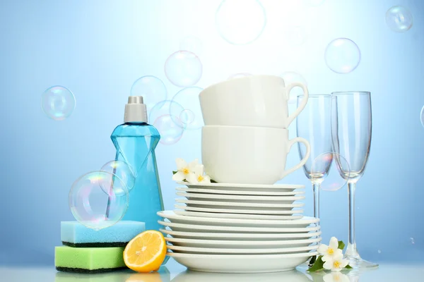 Empty clean plates, glasses and cups with dishwashing liquid, sponges and l — Stock Photo, Image